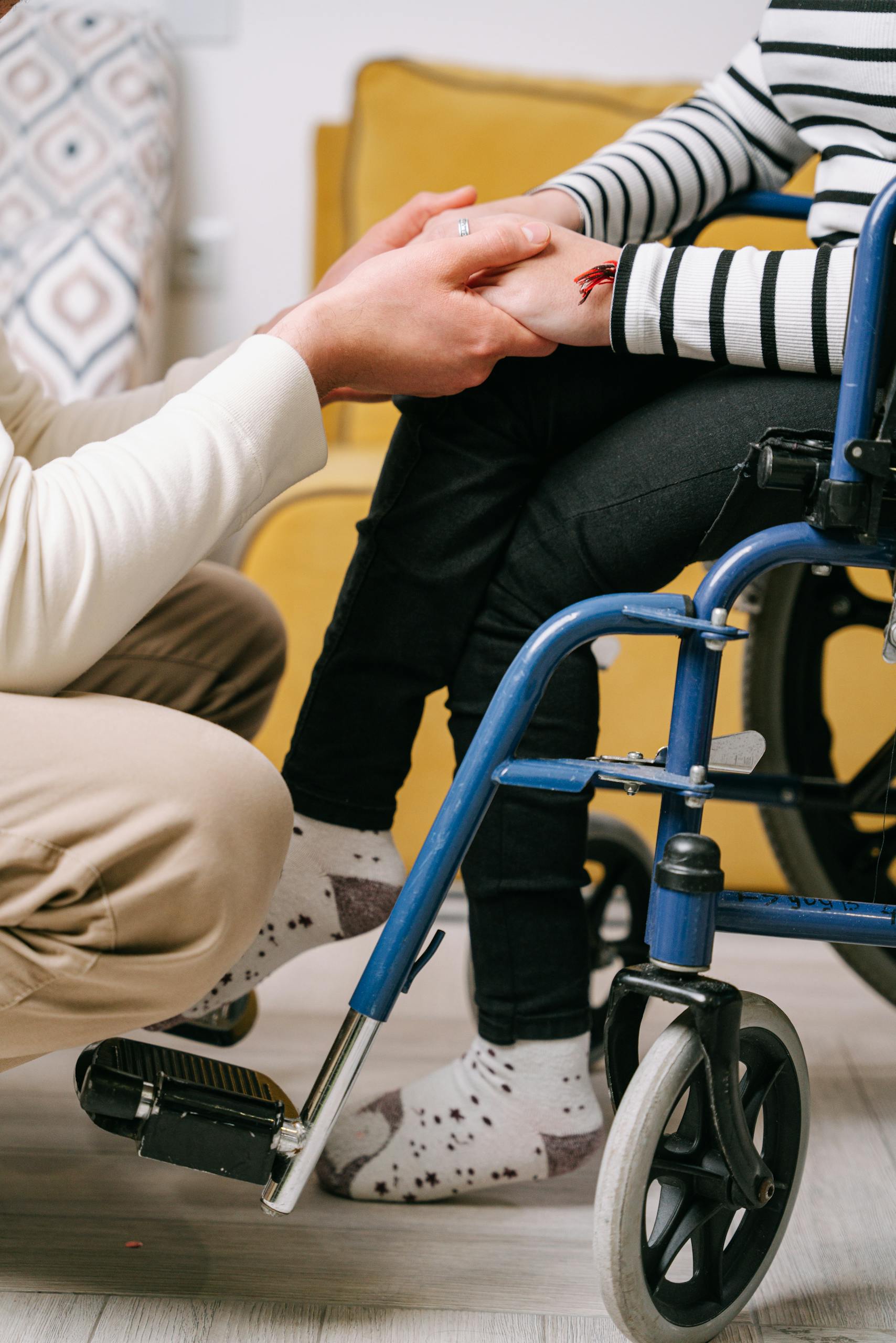 Supportive interaction between caregiver and wheelchair user, showing compassion.